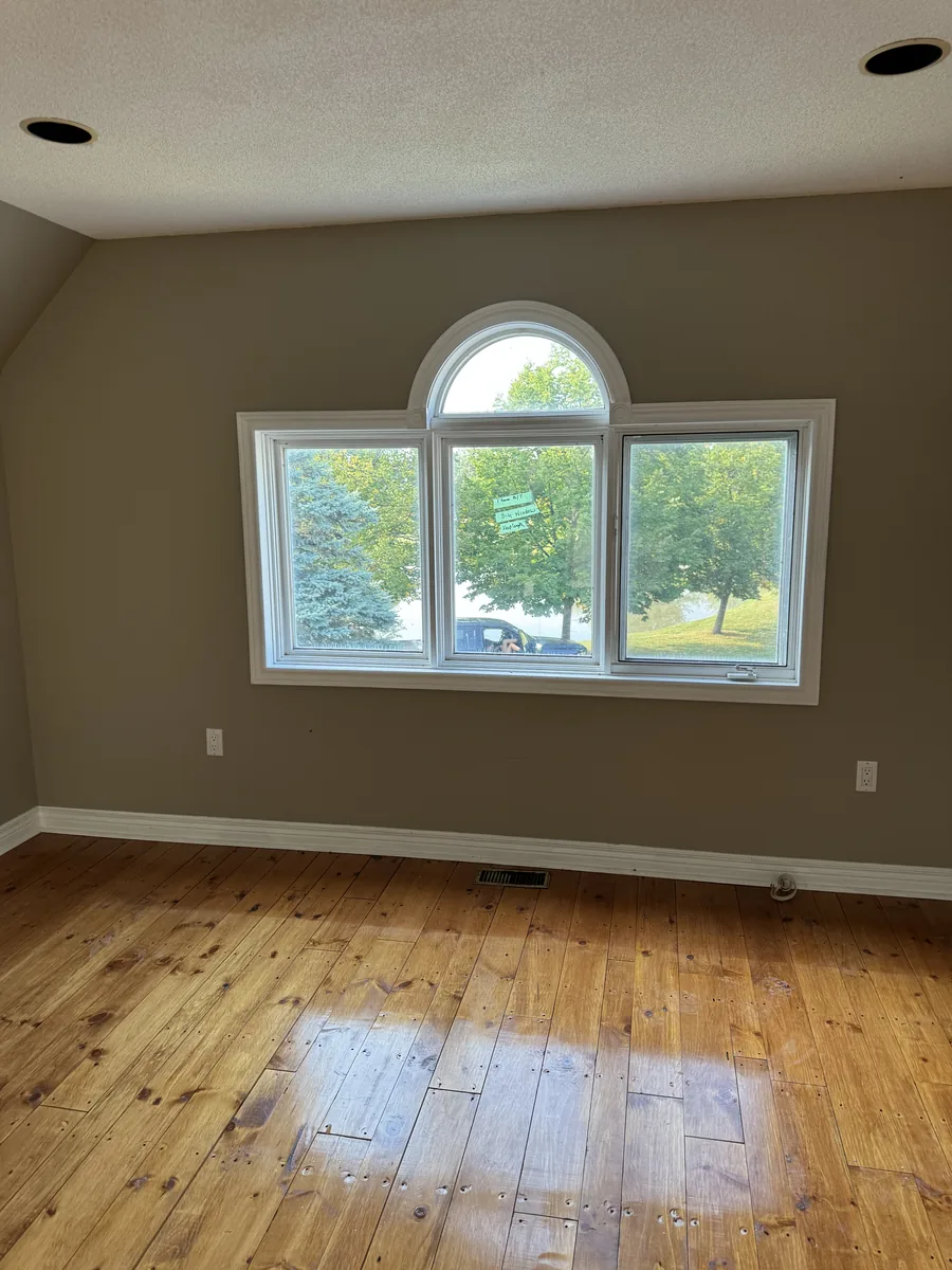 Arched triple window finished inside the Burlington estate over restored wood floors