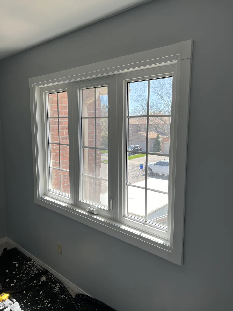 New white casement windows with colonial grills, finished inside the Oakville home