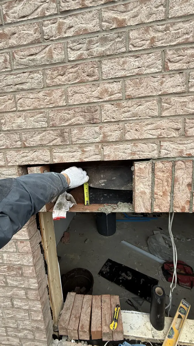 New steel lintel being set into the brick coursing during window enlargement in Pickering