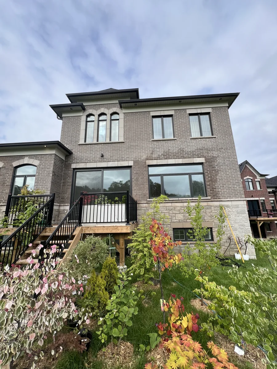 Rear elevation of the Kleinburg estate with new charcoal-framed windows in grey brick and stone, installed by Direct Windows
